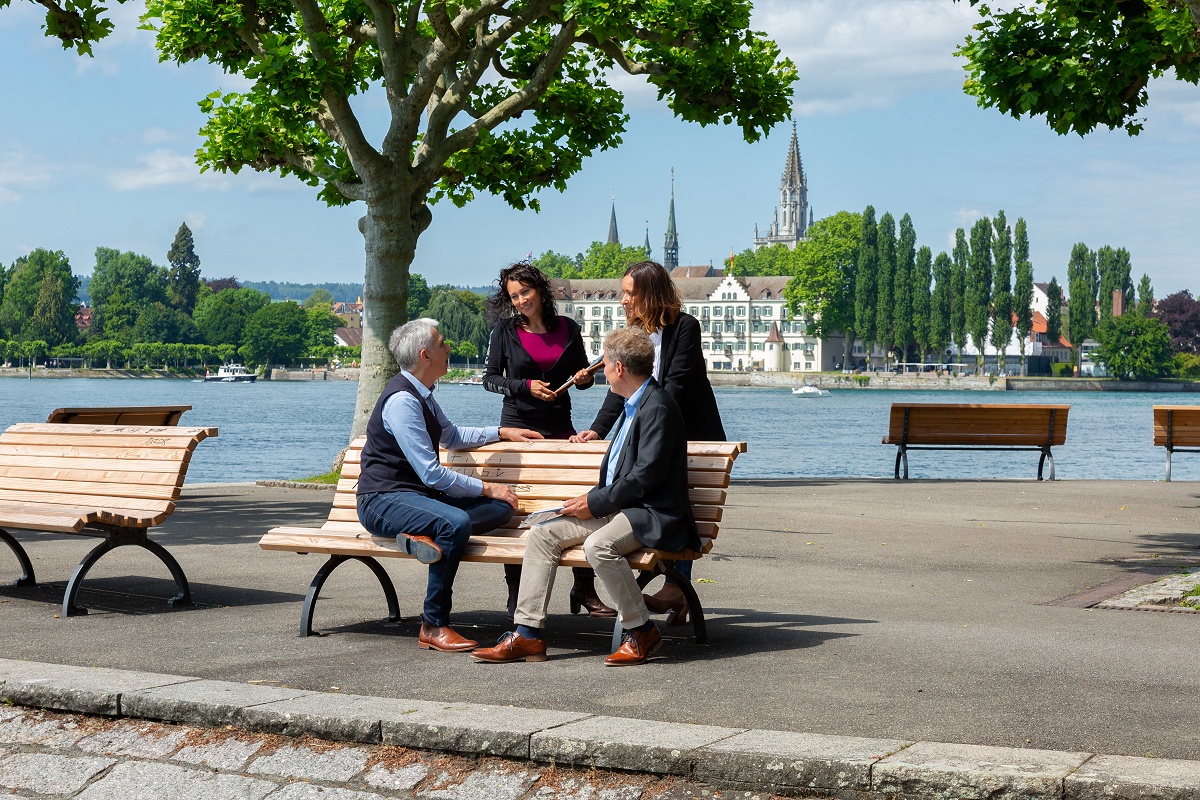 vier Personen im Gespräch an der Bodensee Promenade